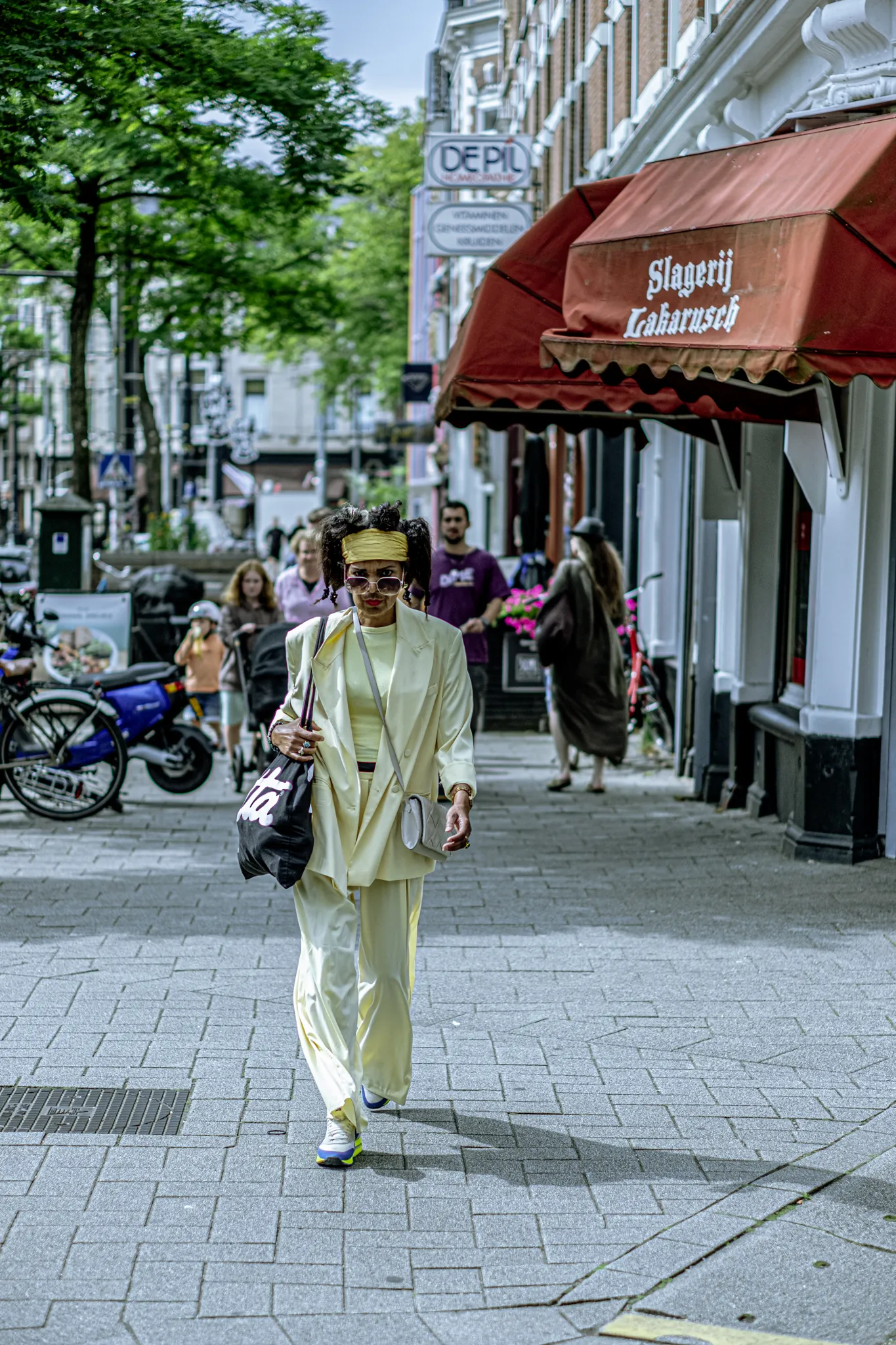 Street photography in the Netherlands Rotterdam Binnenweg full body portrait of woman in yellow dress.