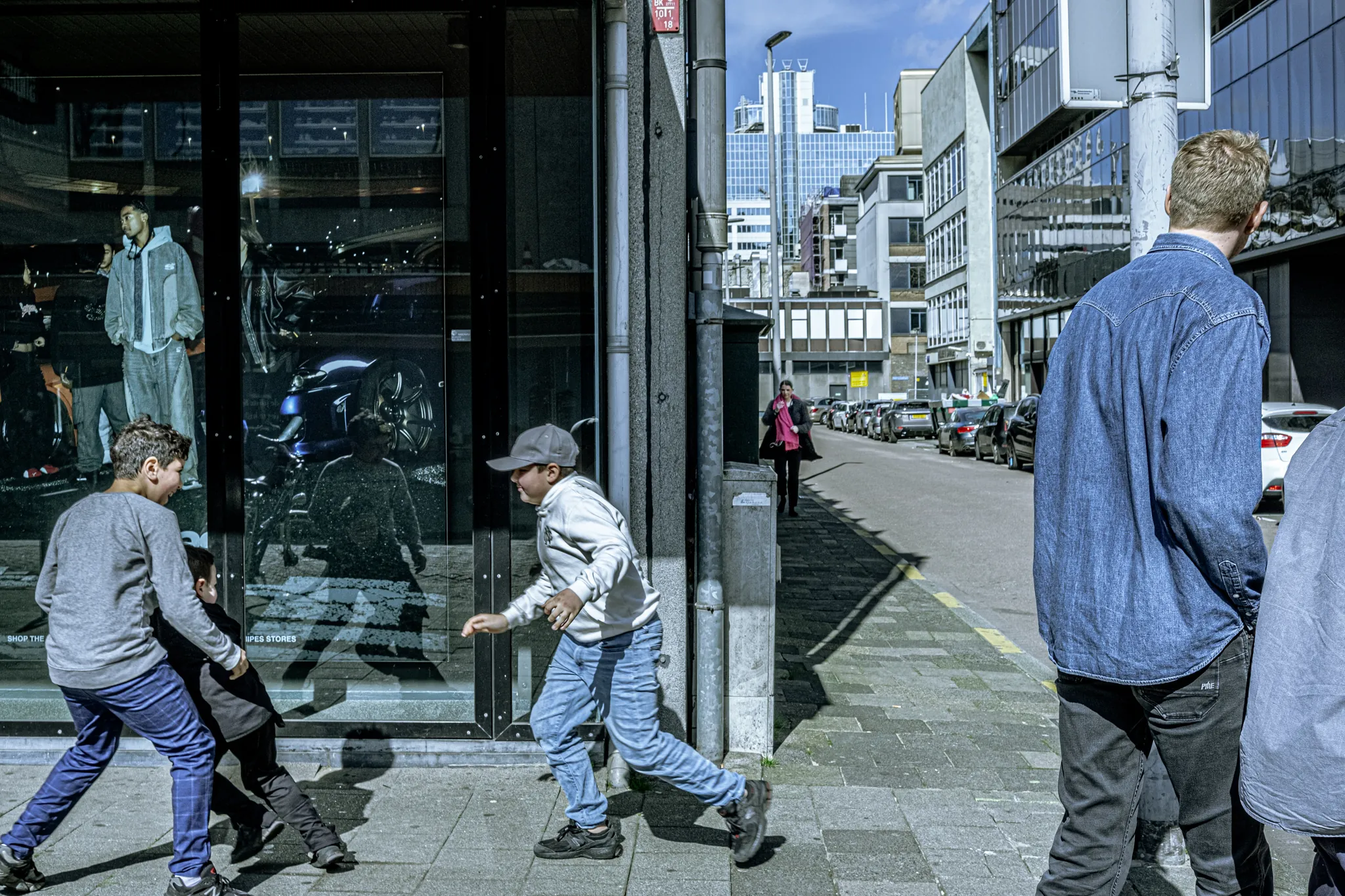 Street photography in the Netherlands Rotterdam Lijnbaan 3 boys playing on the streets.