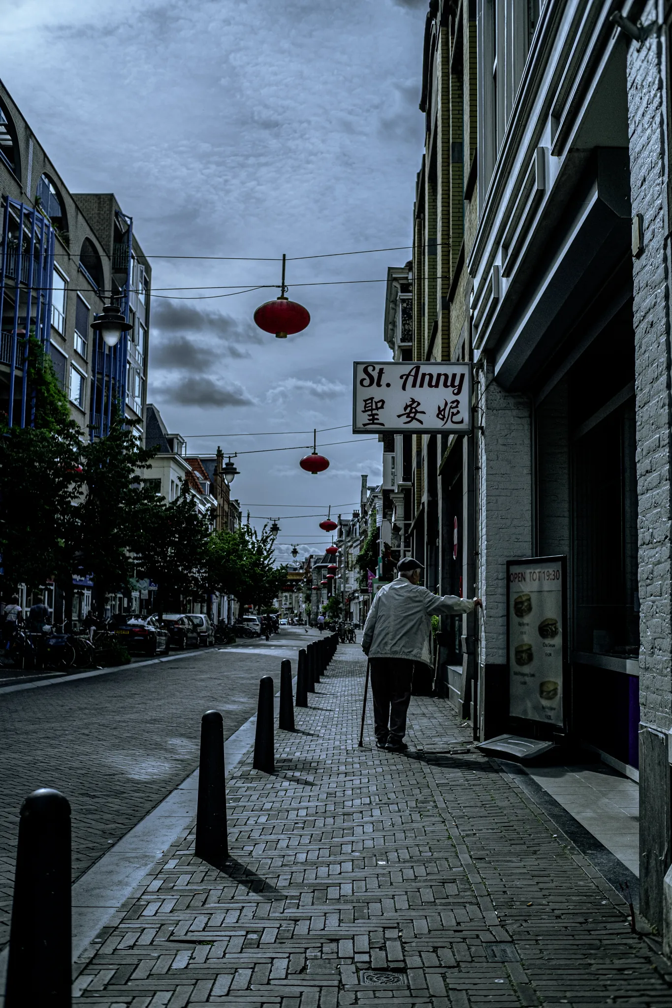 Street photography in the Netherlands Den hague at st.anny old man leaning on a wall.