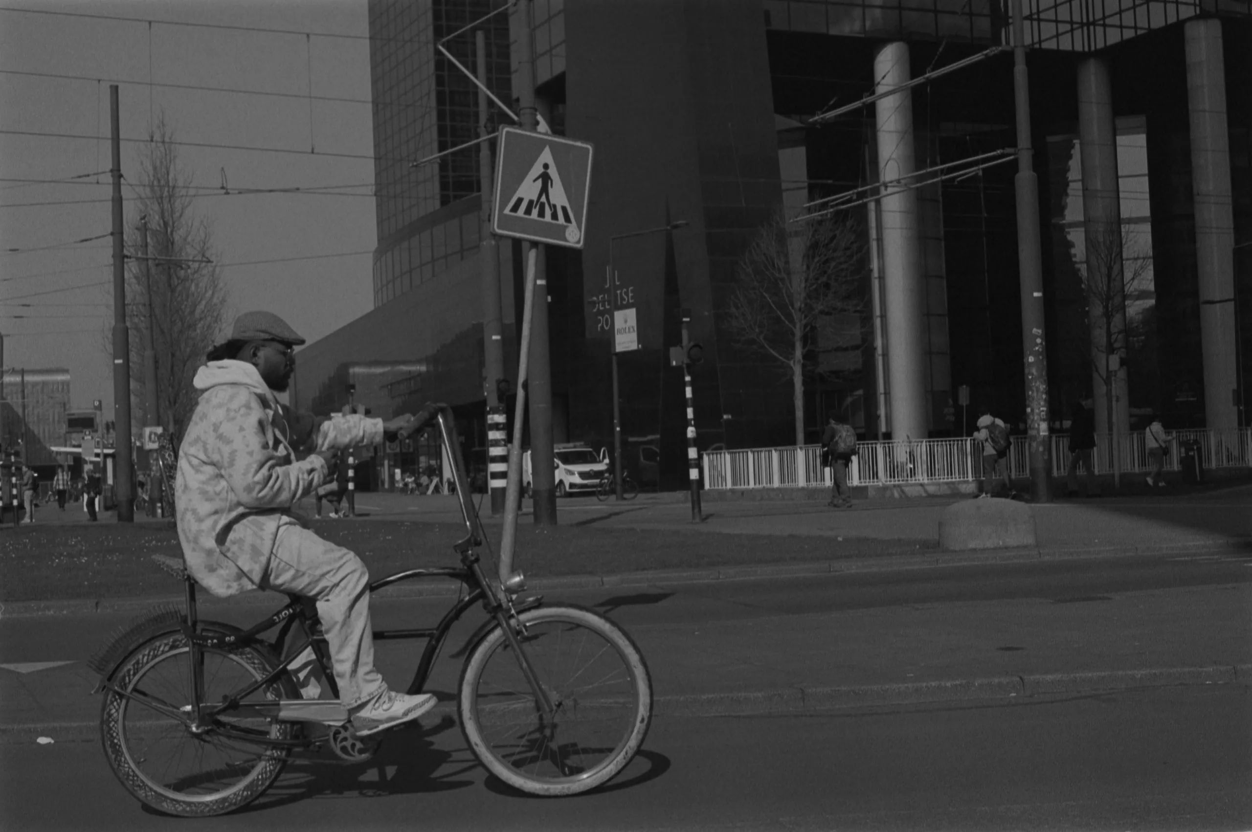 Street photography in the Netherlands Rotterdam close to central station of a man on a special bike in B&W kodak tmax 400.