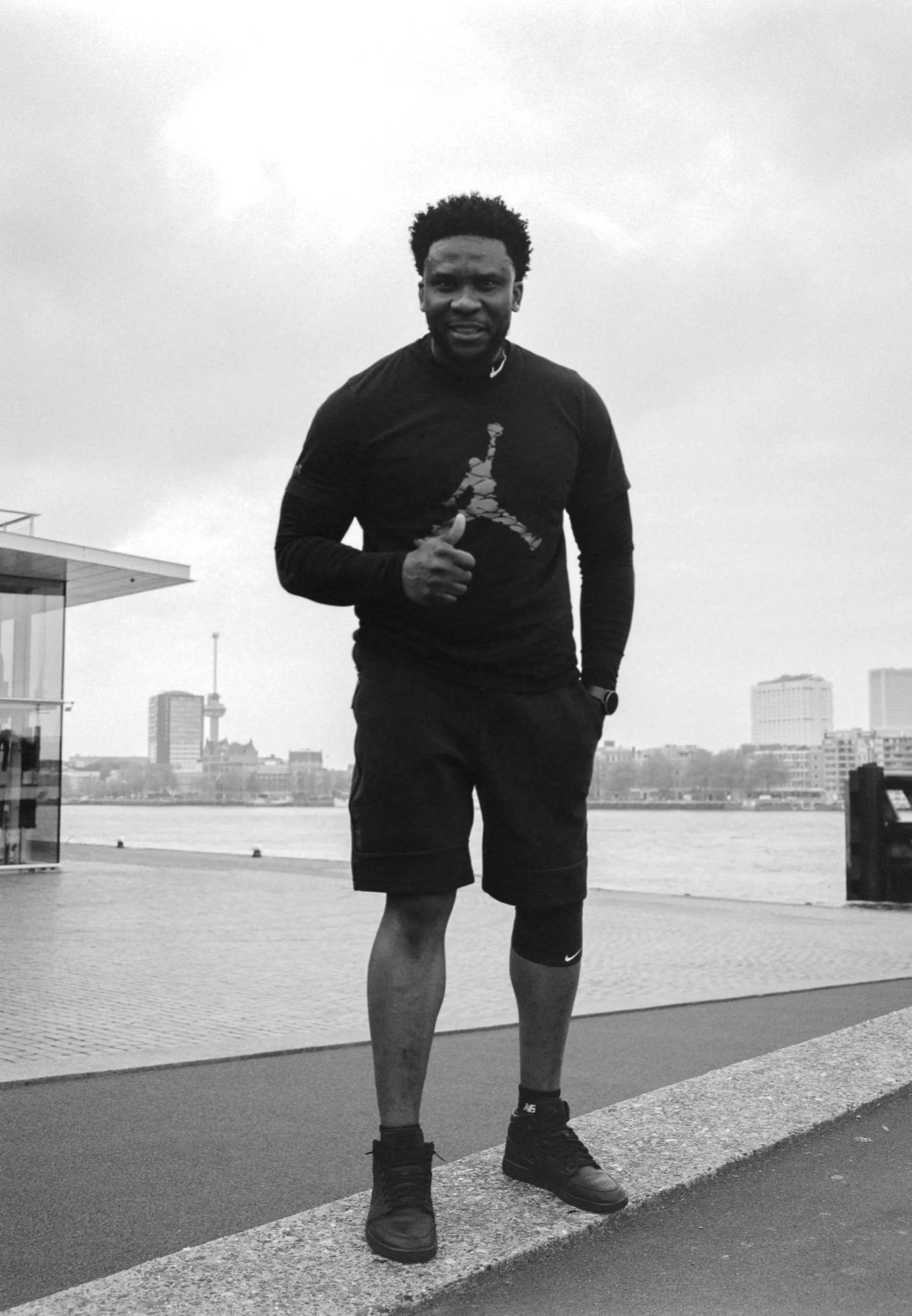 Street photography portrait in the Netherlands Rotterdam erasmusbrug of a man running on medium format film B&W taken on a fuji ga645.