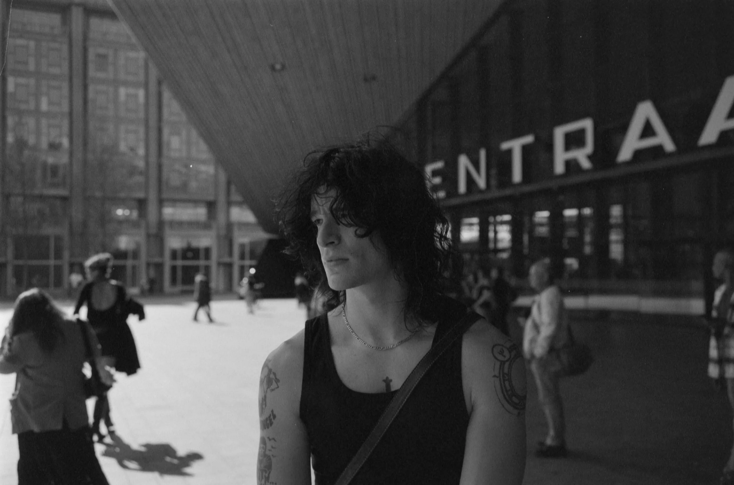 Street photography portrait in the Netherlands Rotterdam central station of a man posing on 35mm format film B&W ilford delta 400.