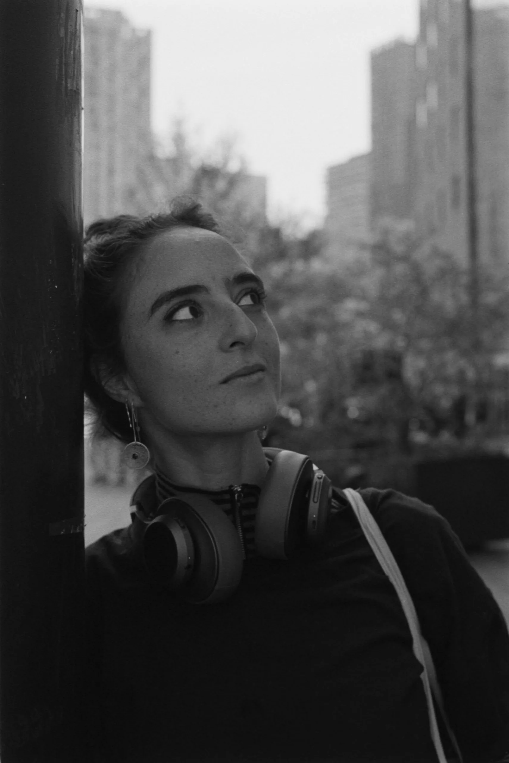 Street photography portrait in the Netherlands Rotterdam close to the markthal of a girl posing and leaning on a structure.