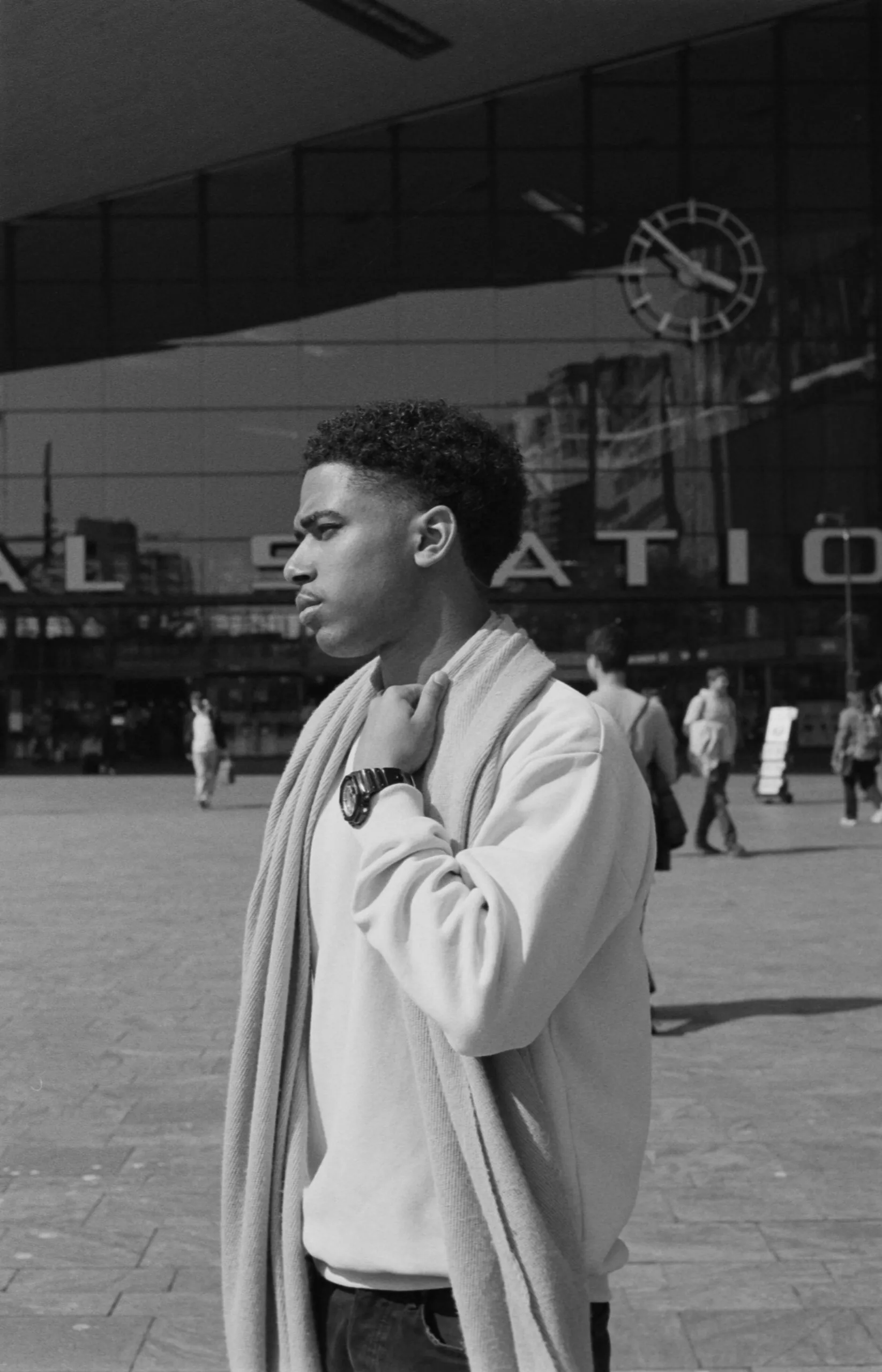 Street photography portrait in the Netherlands Rotterdam central station of a man posing with his watch.