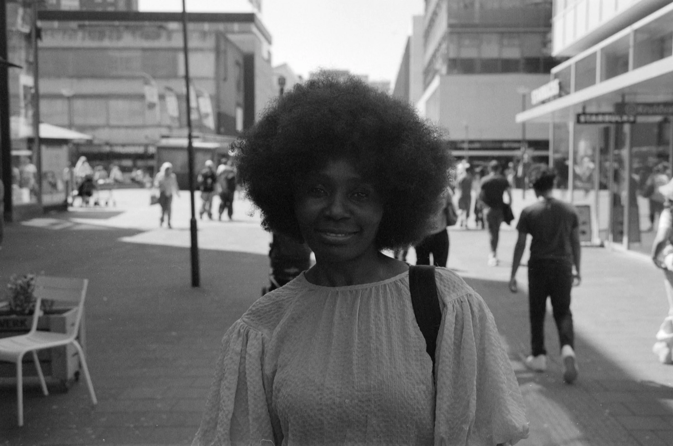 Street photography portrait in the Netherlands Rotterdam hoogstraat of a woman posing on 35mm format film B&W ilford delta 400.