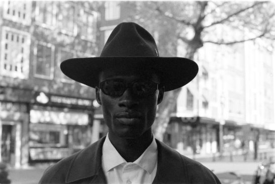 Man with hat posing on black and white film trix400.