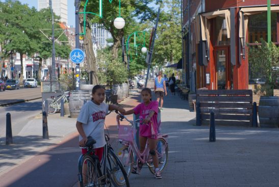 Two young woman posing infront of the Fujifilm XE-3 with there bicycles.