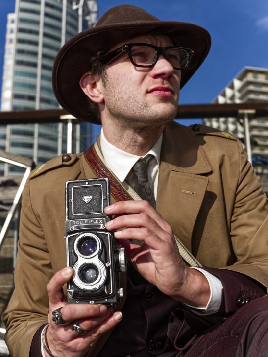 Street portret man holding rolleiflex rotterdam.