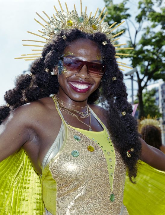 A woman posing at the summer carnaval 2025 in Rotterdam, photo taken with a fuji ga645 with on camera flash and kodak gold 200.
