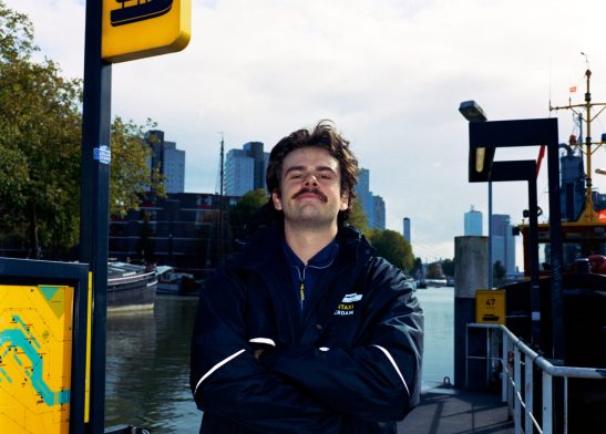 Portrait of a man posing at the watertaxi Rotterdam Wijnhaven on medium format film kodak gold 200.