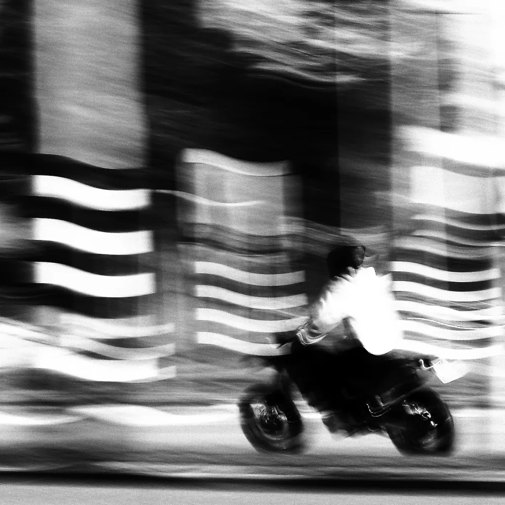 Black and white motorcycle in street Rotterdam taken with fujifilm xe3 and slow shutterspeed.